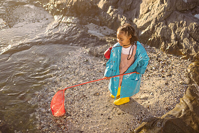 Buy stock photo Fishing, net and girl on an adventure at the beach with smile, happy and travel by the ocean in Spain. Nature, playful and child catching rocks by the sea on holiday for peace, relax and happiness