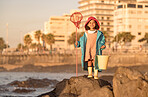Girl, fishing and beach adventure for freedom, peace and learning skill development. Child, happy and ready with fishing net, bucket and fun outdoor activity, portrait and happiness in sunshine