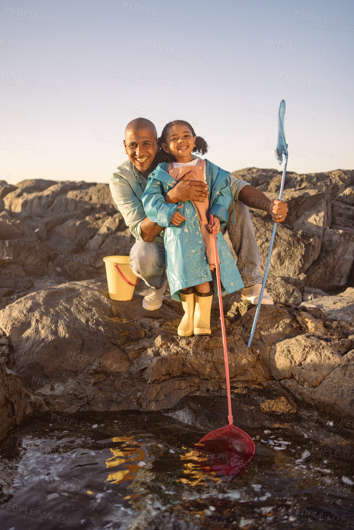 Buy stock photo Father, girl or bonding and fishing by beach, ocean or sea rock pools with plastic bucket and nets on summer holiday. Portrait, smile or happy child or kid with man catching fish, shrimp or muscles