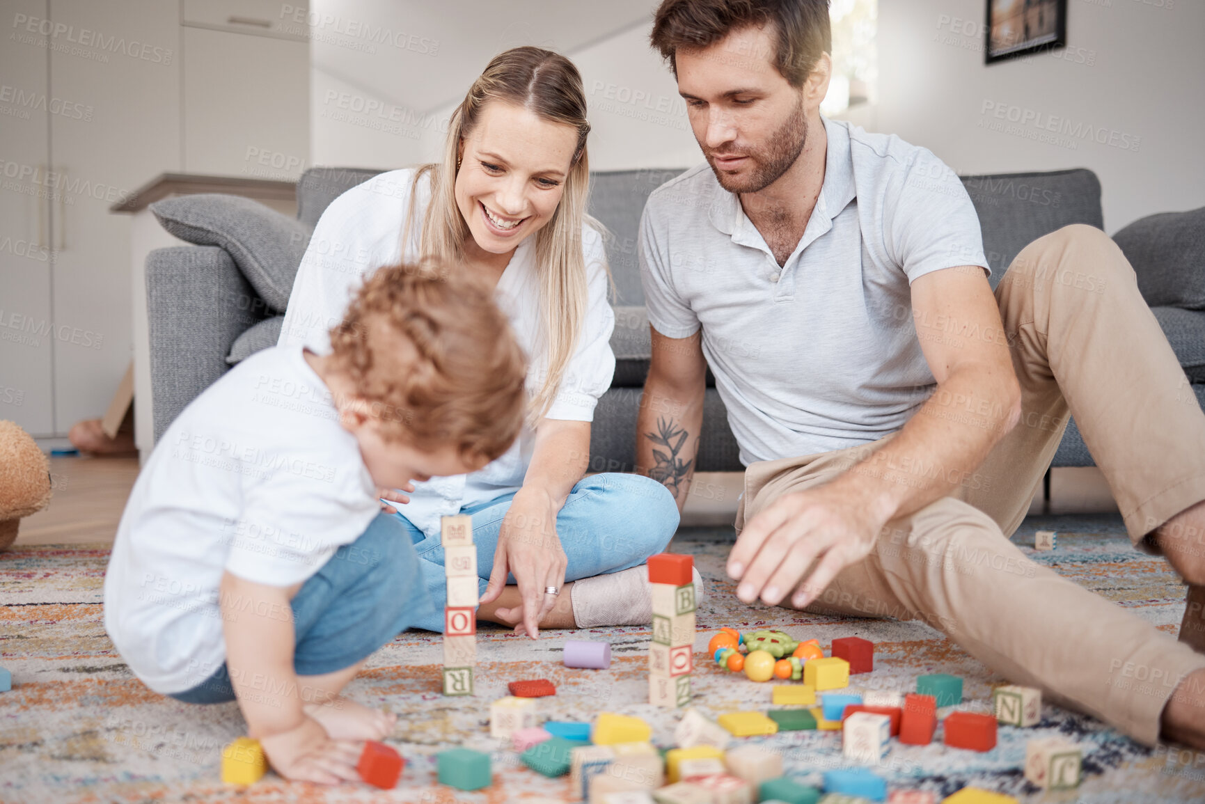 Buy stock photo Learning, happy and family with building blocks on living room floor for child development skills. Mother, dad and young child on carpet with toys in family home for bonding, teaching and fun.

