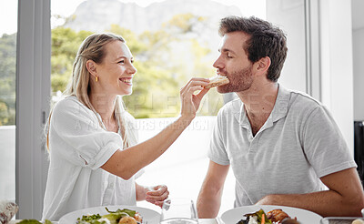 Buy stock photo Couple, food and eating lunch with a woman feeding her man on a romantic date at home at the dining table. Health, nutrition and diet with a husband and wife eating delicious meal or lunch