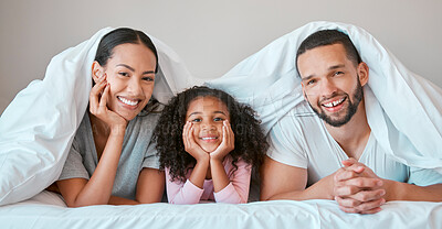 Buy stock photo Relax, happy and girl with her parents in bed for security, love and safety under blanket in their family home. Support, smile and portrait of a child with her mother and father in the bedroom