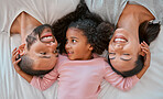 Happy, love and family relaxing on the bed together in a bedroom of their house to bond and relax. Happiness, smile and parents lying, talking and bonding with their girl child in room at their home.