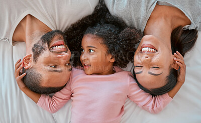 Buy stock photo Happy, love and family relaxing on the bed together in a bedroom of their house to bond and relax. Happiness, smile and parents lying, talking and bonding with their girl child in room at their home.