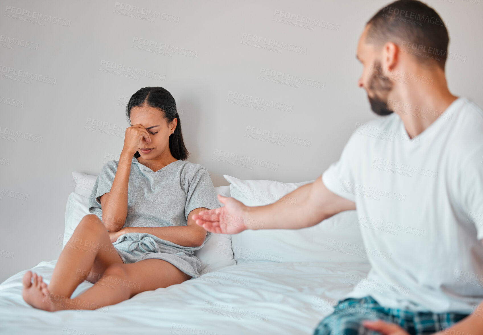 Buy stock photo Comfort, crying and sad couple in bed after fight, argument and disagreement at home. Love, marriage and young man reaching to console upset and depressed woman sitting in bedroom to fix relationship