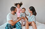 Family, love and relax on bed in home bedroom, having fun or playing. Support, bonding and care of happy father, mother and baby with girl, smiling and enjoying quality time together in family house.