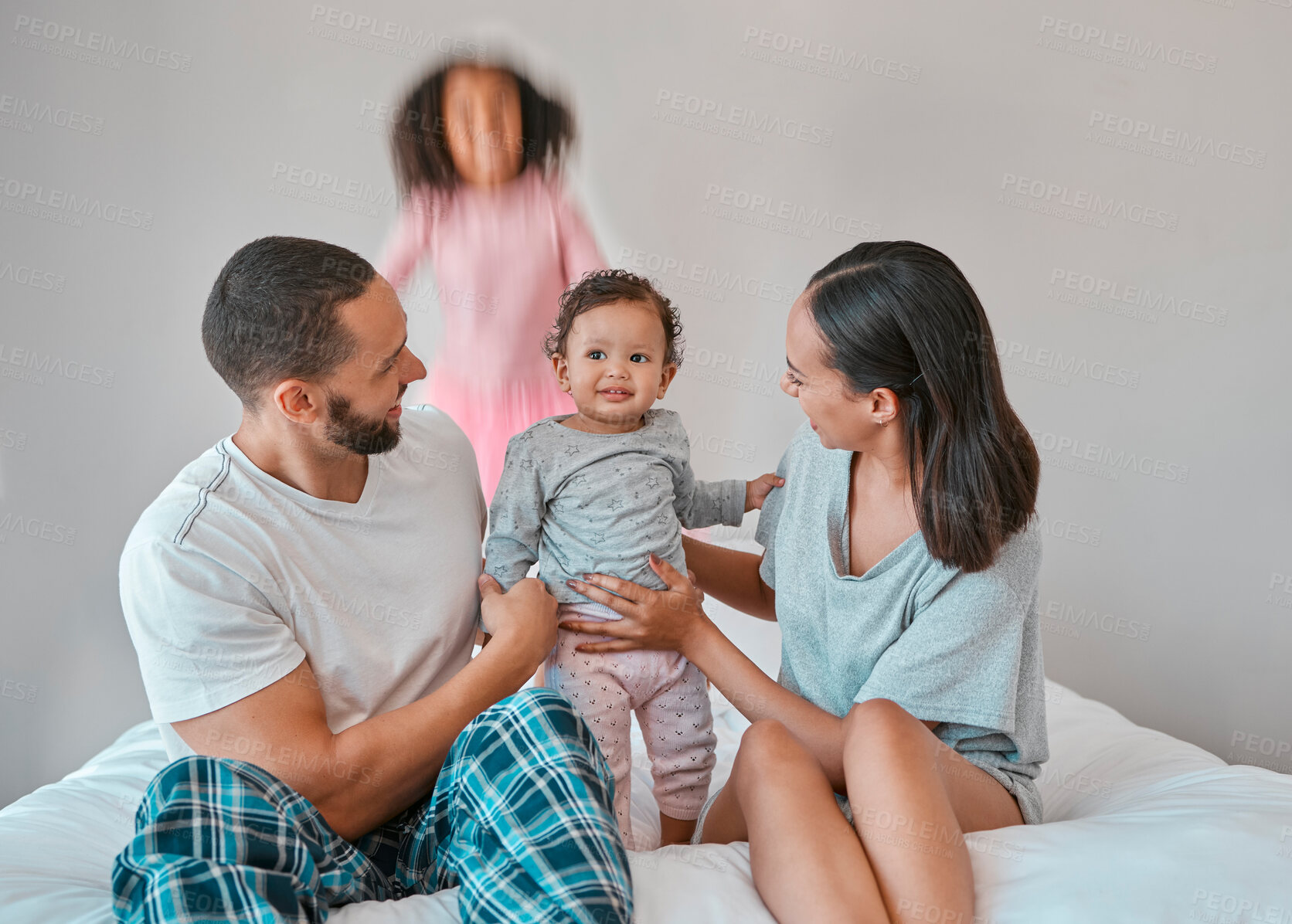 Buy stock photo Family, baby and girl jump on bed in bedroom, having fun or playing. Support, love and care of happy father, mother and children bonding, smiling and enjoying quality time together in family house.