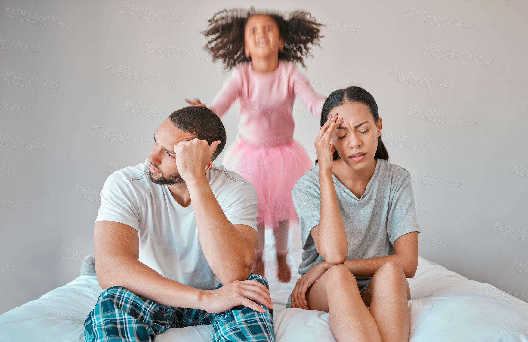 Buy stock photo Stress, divorce and couple with a child on the bed with her parents in an argument or disagreement. Tired, break up and young angry mother and father with a adhd girl jumping in bedroom at their home
