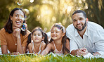 Bubbles, happy and family in the park for a picnic, relax and quality time on the grass in Canada. Spring, smile and portrait of girl children with mother and father with love and care in nature