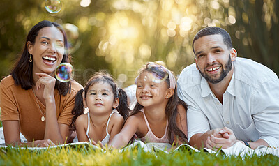 Buy stock photo Bubbles, happy and family in the park for a picnic, relax and quality time on the grass in Canada. Spring, smile and portrait of girl children with mother and father with love and care in nature
