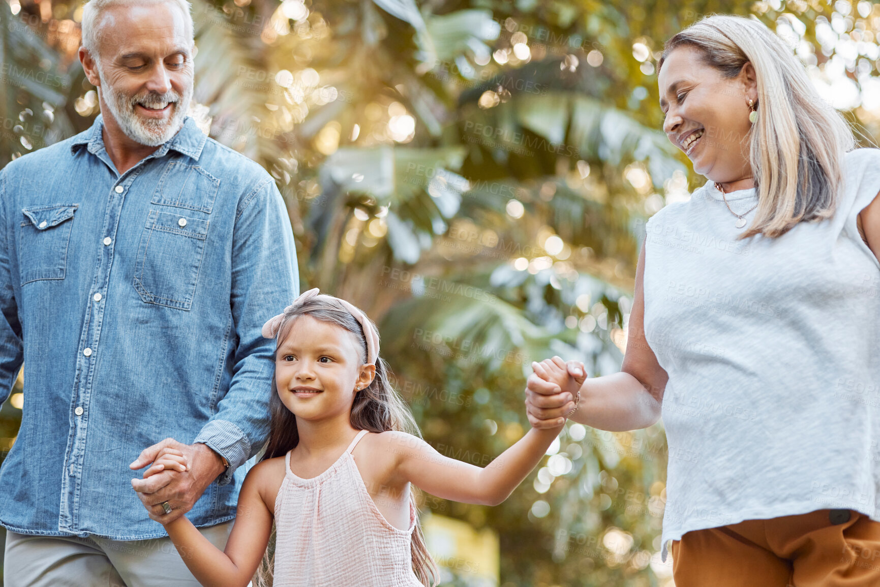 Buy stock photo Park, holding hands and grandparents with child for outdoor walking, nature wellness and development in summer, holiday and travel. Happy girl with senior family in garden bonding together with love