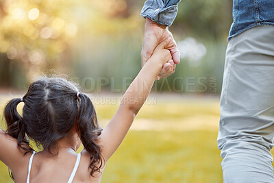 Buy stock photo Holding hands, care and girl with father in a park with safety, support and security. Walk, trust and back of a child with dad in a backyard, field or nature in countryside for outdoor quality time 