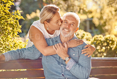 Buy stock photo Love, relax and happy with old couple in park bench for retirement, support and affectionate. Bonding, kiss and hug with portrait of man and woman in countryside for smile, nature and marriage 