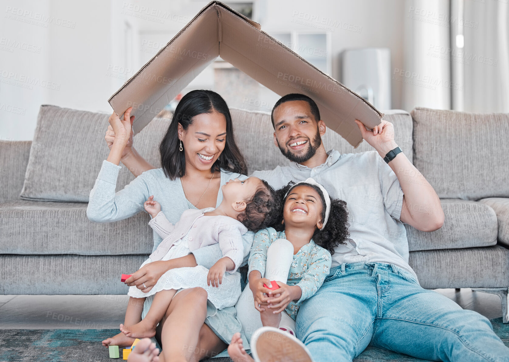 Buy stock photo Family, children and insurance with a mother, father and daughter siblings in a living room of their home together. Security, safety and homeowner with parents holding cardboard to cover sister kids