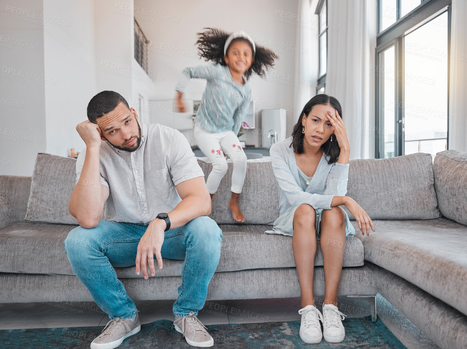 Buy stock photo Tired, couple and family with adhd girl jump fast on sofa in house living room or home. Man, woman and parents with burnout, depression or anxiety from autism, energy and mental health kid and stress