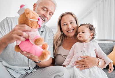 Buy stock photo Mature, couple and baby with a toy while babysitting grand daughter with love, care and affection for fun playing. Caring, living room and grandfather, grandmother and child bonding with teddybear