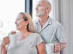 Elderly couple, hug and coffee by window with smile in contemplation, vision or morning routine at home. Happy senior man and woman smiling looking out glass while enjoying a warm drink together