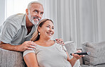 Relax, remote and senior couple watching tv show, global news or streaming subscription movie on home living room date. Love, television or retirement lifestyle of happy elderly man and woman bonding