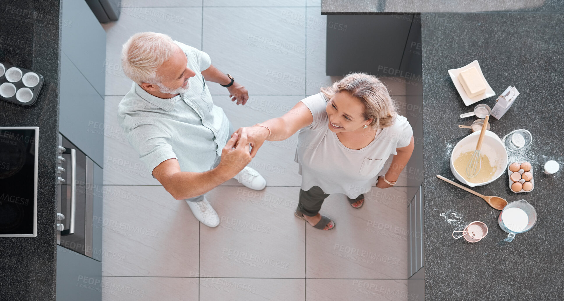 Buy stock photo Top view dancing and senior couple in kitchen having fun, bonding and enjoy retirement together. Love, romance and aerial of happy elderly man and woman cooking, baking and dance on weekend at home