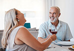 Couple, wine and senior man and woman toast in anniversay celebration with a delicious meal in the family home. Red wine, love and husband and wife cheers for loving romantic relationship