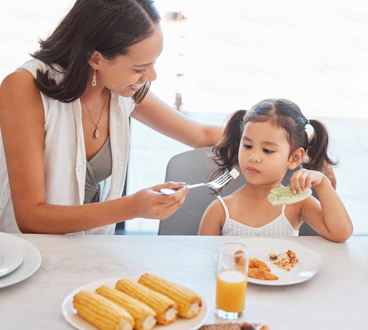 Buy stock photo Mother, food and eating with child while feeding healthy diet or nutrition in the family home kitchen. Woman, child and hungry little girl and female eat lunch or meal for health and wellness 