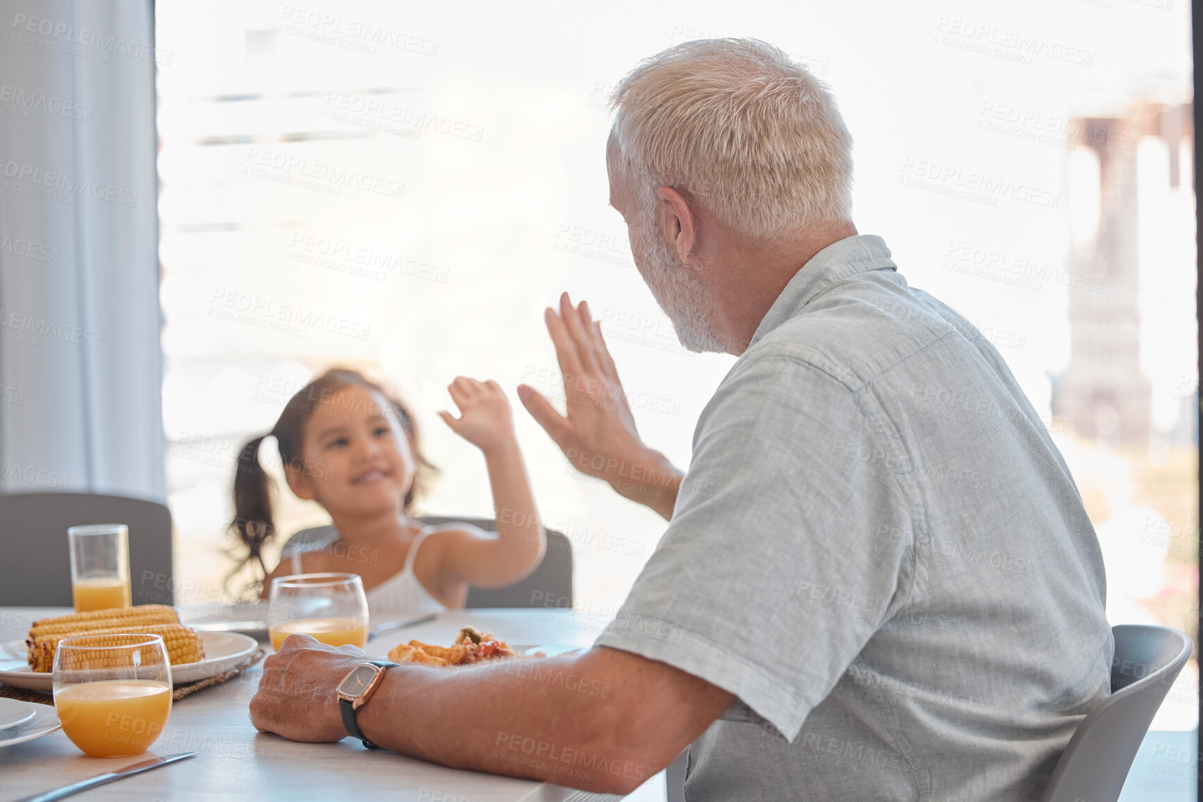 Buy stock photo High five, breakfast and family with a girl and grandfather sitting at a dining room table for eating food. Motivation, health and children with a senior man encouraging his grandchild to eat healthy