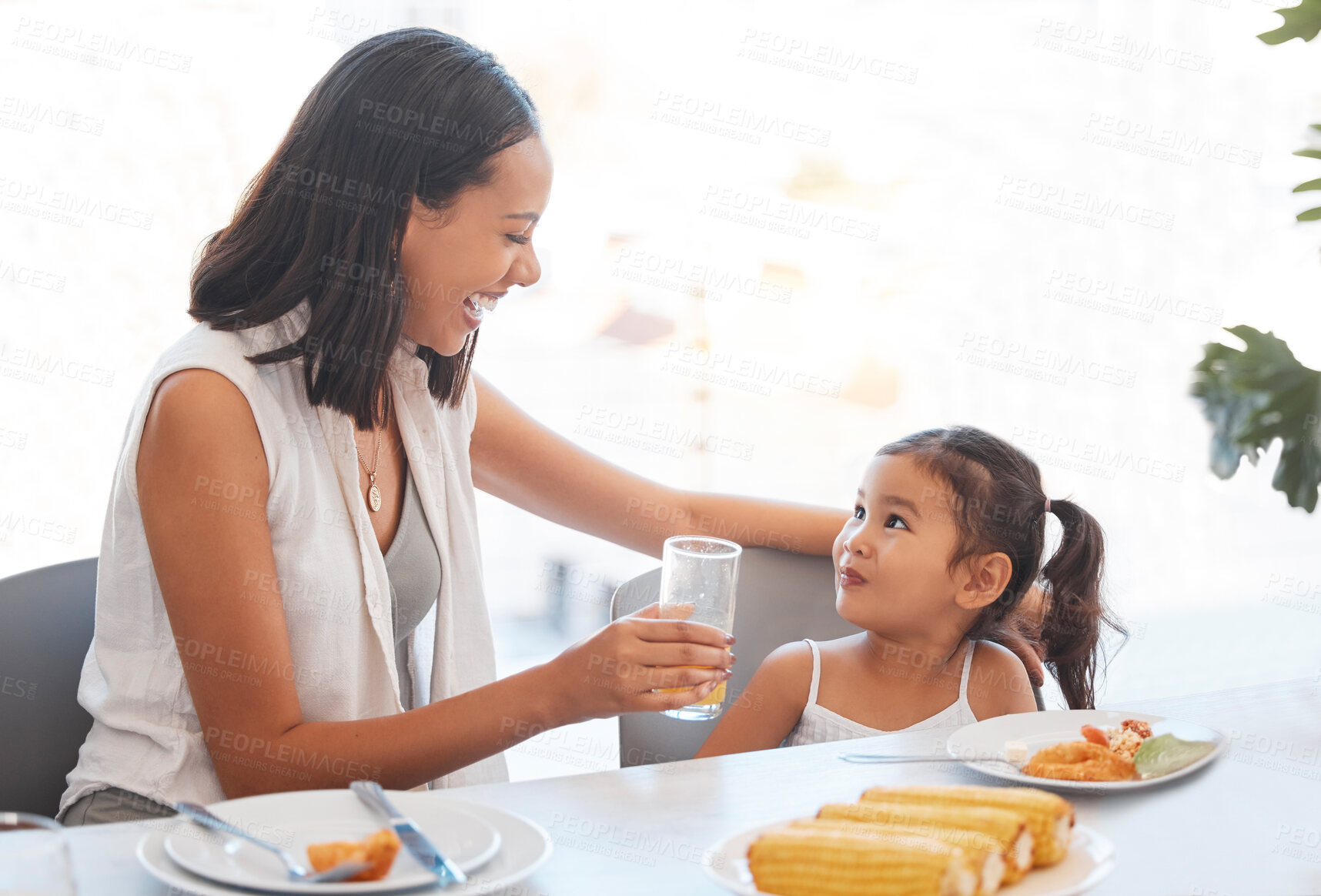 Buy stock photo Woman, food and eating at home for health, wellness and diet nutrition at the dining table. Meal, lunch and mother and daughter eat and drink juice together for hungry child in the family home