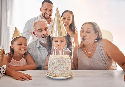 Buy stock photo Birthday, family and girl blowing candles on cake with party hats, parents and grandparents in home. Happiness, big family and happy young child make a wish on festive celebration and birthday party