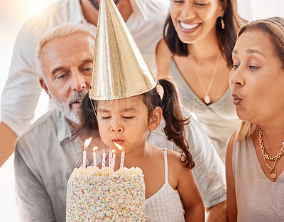Buy stock photo Blowing candles, birthday cake and happy family with a girl to celebrate with a wish, food and eating at a birthday party. Happy birthday, smile and kid with parents and grandparents at a celebration