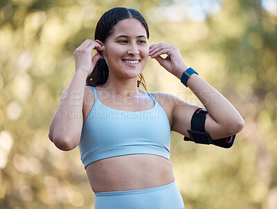 Buy stock photo Woman, fitness and music with an athlete wearing earphones for motivation songs before a exercise workout in nature. Working out, running and athletic female streaming a podcast on her phone outside