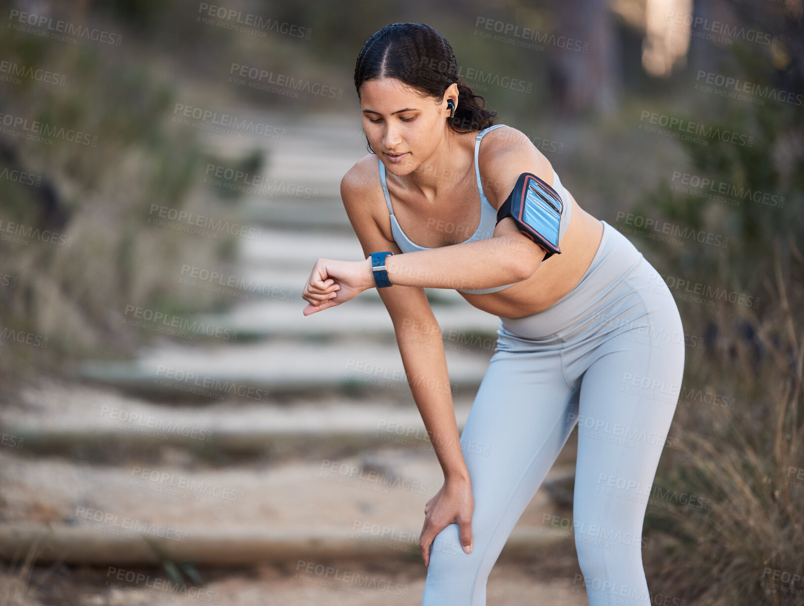 Buy stock photo Fitness, running and woman with a smartwatch doing a cardio workout in the woods for health. Sports, wellness and athlete training for a race, marathon or exercise in nature in a forest with a watch.