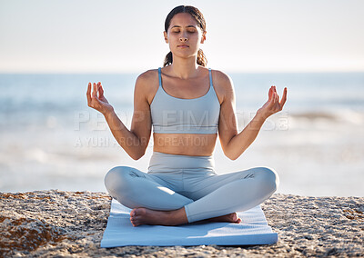 Buy stock photo Calm, beach and woman doing meditation exercise for zen, health and wellness of the mind and body. Spiritual, fitness and healthy girl in lotus pose doing yoga or pilates workout by the ocean or sea.