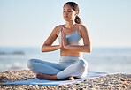 Woman, yoga and beach for fitness, health and wellness with a mindfulness exercise in nature environment. Sea, pilates and fit female in lotus pose on a yoga mat for stress relief and mental health