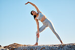 Fitness, health and yoga with a woman athlete stretching on a rock at the beach for mental health or wellness. Exercise, workout and training with a female yogi outdoor in nature for mindfulness