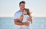 Hug, love and couple at the beach for a date, travel and summer commitment together. Affection, happy and portrait of a man and woman hugging for comfort, happiness and marriage at the ocean