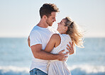 Love, beach hug and couple smile together with ocean background for peace, relax in nature and romance vacation happiness. Happy man, laughing woman and relationship bliss on a travel holiday by sea 