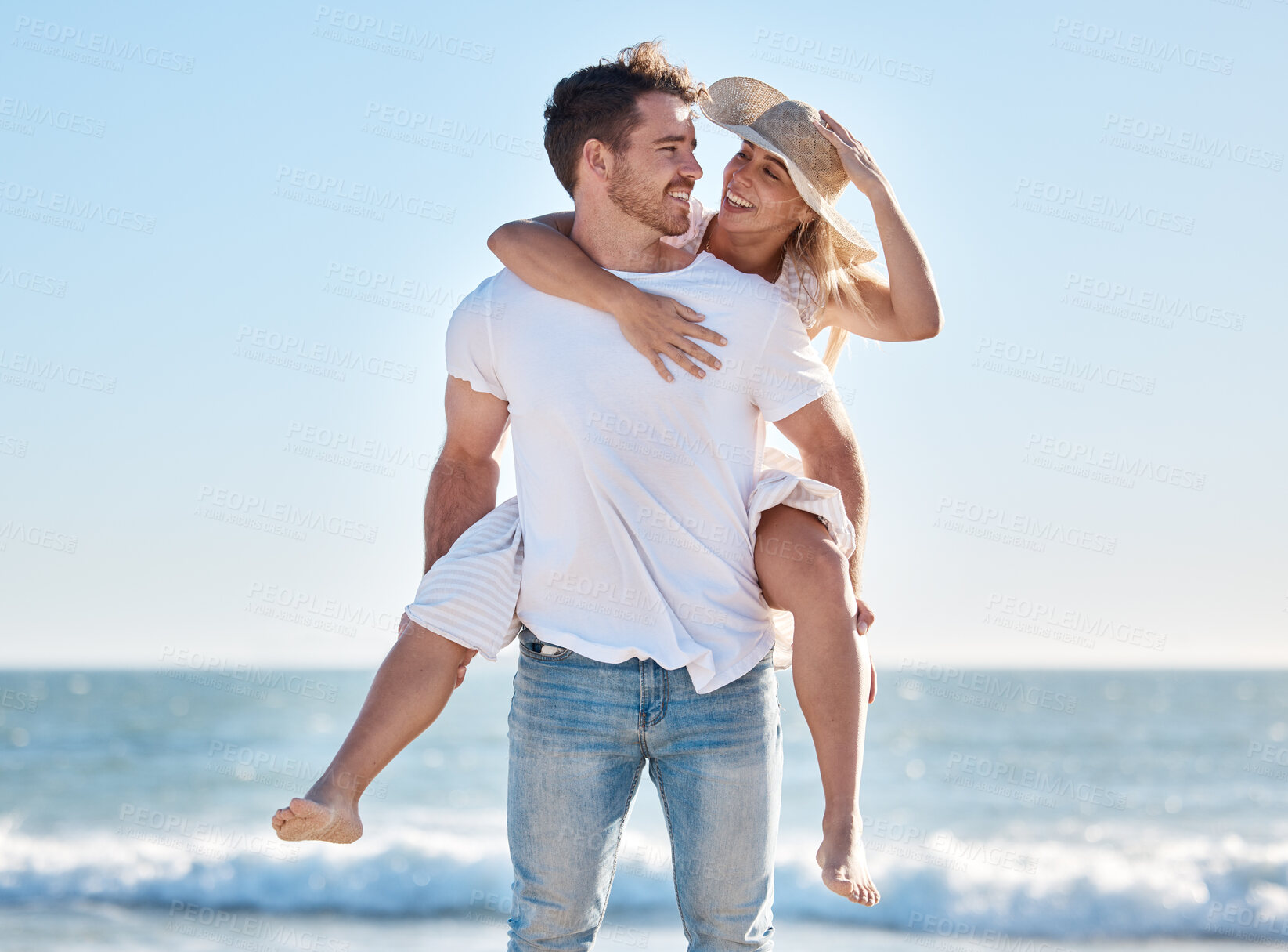 Buy stock photo Love, couple and piggy back at beach on vacation, holiday or summer trip outdoors. Romance, support and happy man carrying woman on shoulders, enjoying quality time together or having fun at seashore