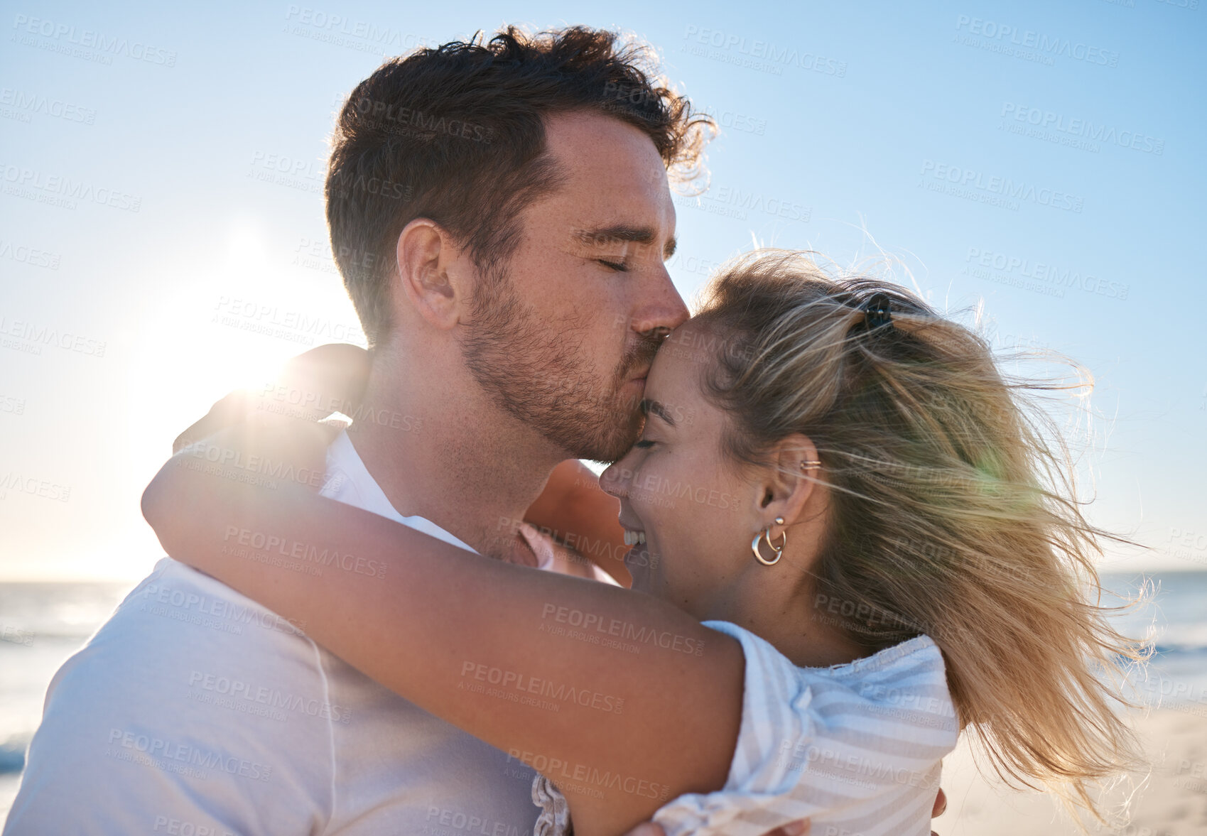 Buy stock photo Beach, love and man kissing his wife while on a romantic holiday by the seaside in Australia. Happiness, honeymoon and couple hugging in nature by the ocean on a summer vacation, adventure or journey
