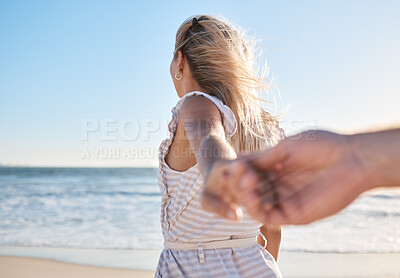Buy stock photo Hands, love and walking with a couple on the beach during summer vacation for romance or bonding. Sea, travel and holding hands with a woman leading her man on a walk by the ocean water on holiday