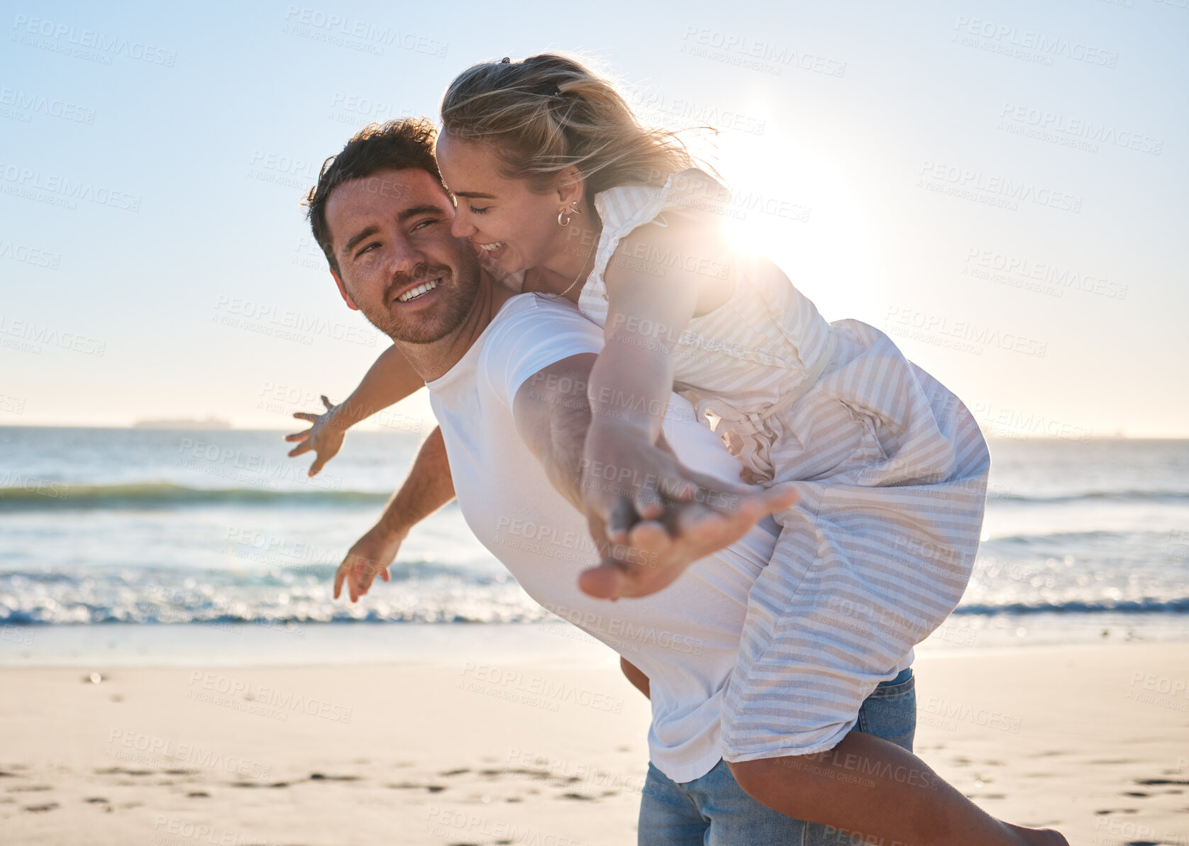 Buy stock photo Happy, couple and piggyback walk on the beach for love, travel or summer vacation bonding together in the outdoors. Man carrying woman on back with smile enjoying playful fun time walking by the sea