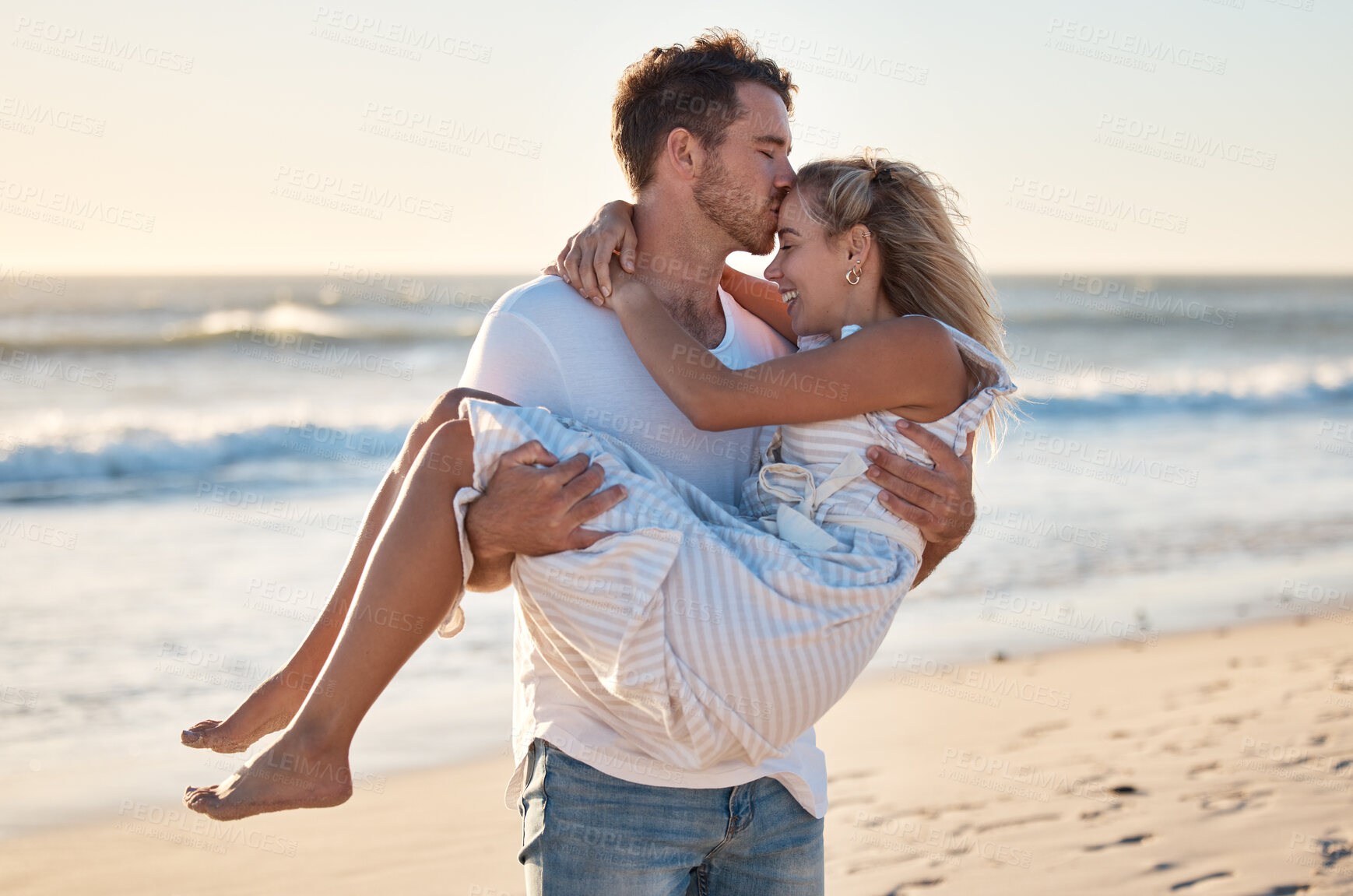 Buy stock photo Kiss, beach and man carrying woman for romantic sunset embrace on Australia holiday in summer. Couple, love and happy man holding partner with care, gratitude and respect on ocean walk.

