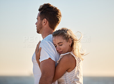 Buy stock photo Couple, hug back and woman at beach with love, smile or happiness for anniversary, honeymoon or vacation by sea. Happy couple, man and girl in ocean wind, happy or bonding together in summer sunset