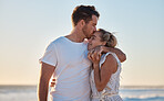 Love, summer and couple kiss at beach for intimacy, romance and loving relationship on honeymoon. Dating, affection and man and woman bonding and enjoy holiday, vacation and weekend together by ocean
