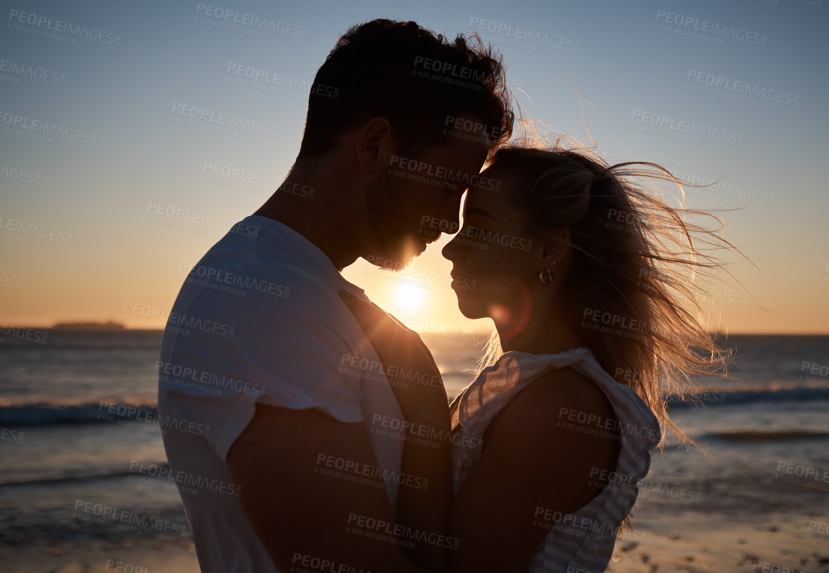 Buy stock photo Sunset, silhouette and couple with love at the beach, affection and quality time on a holiday in Bali. Dark, sunrise and man and woman with care, hug and peace by the tropical water on vacation