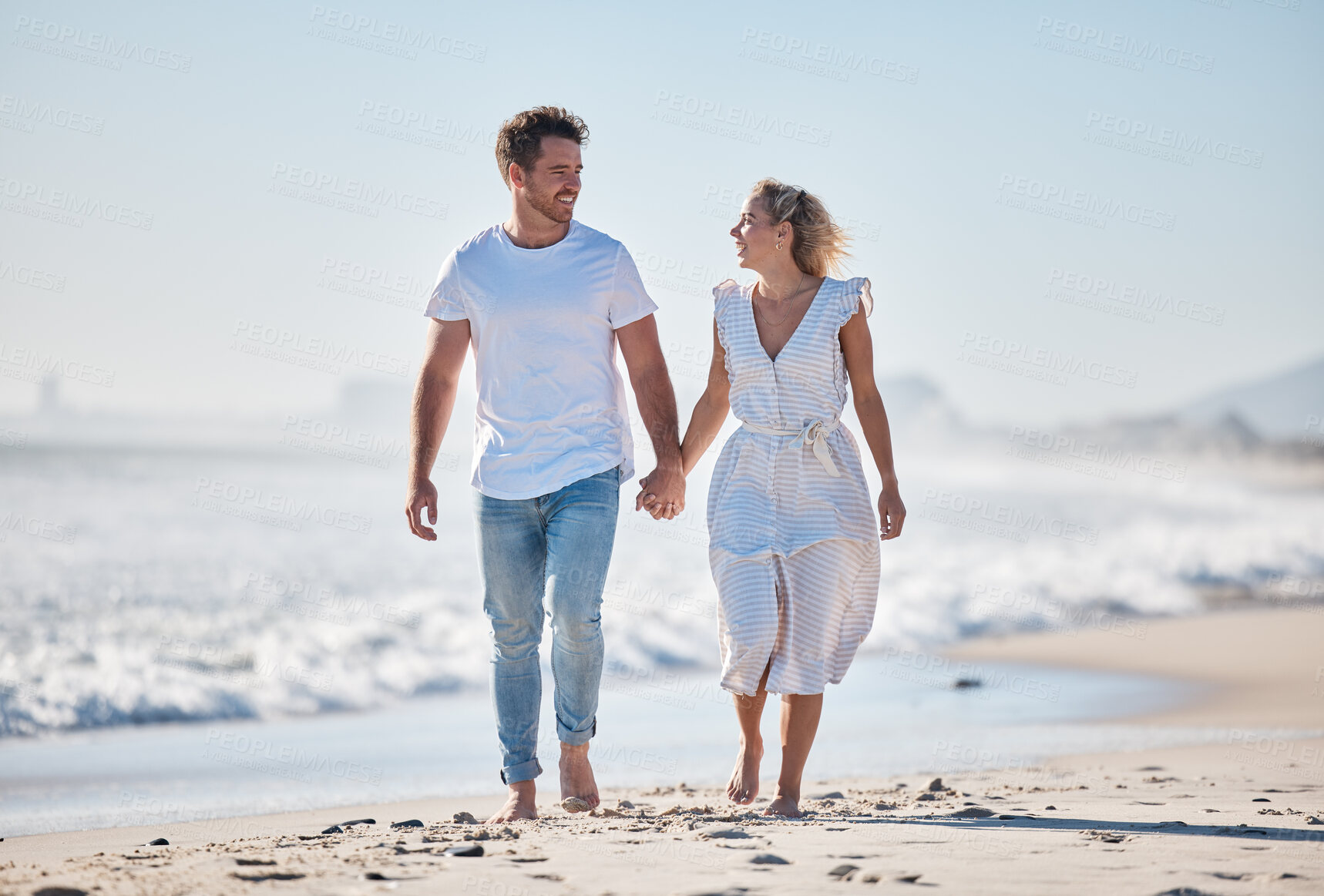 Buy stock photo Couple, beach and holding hands for love, walk or care in relationship bonding together in the outdoors. Happy man and woman walking in romance while enjoying summer vacation on the sandy ocean coast