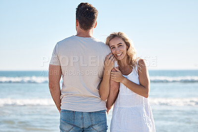 Buy stock photo Couple, hug and love for travel, beach or summer vacation relaxing or bonding together in the outdoors. Woman holding man in loving embrace with smile for happy relationship or traveling by the ocean