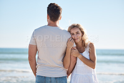 Buy stock photo Love, beach and couple on vacation hug by ocean on luxury summer holiday trip to relax. Back of man, woman with happy smile on date for romance, peace and celebrate bond on blue sea water background 