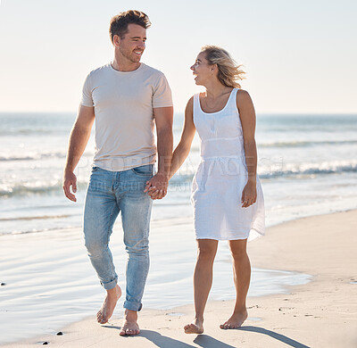 Buy stock photo Holding hands, walking and beach with a young couple on the coast for romance, dating or bonding in summer. Love, travel and walk with a woman and man happy during a walk on the sand together