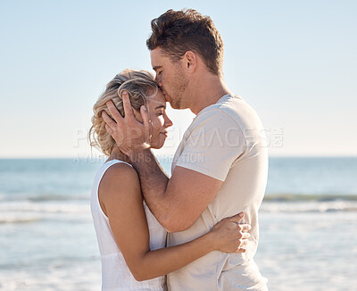 Buy stock photo Couple, love and forehead kiss on beach by ocean, sea or Hawaii water waves in trust, love and security. Smile, happy or bonding woman and man on anniversary summer break in tropical nature location