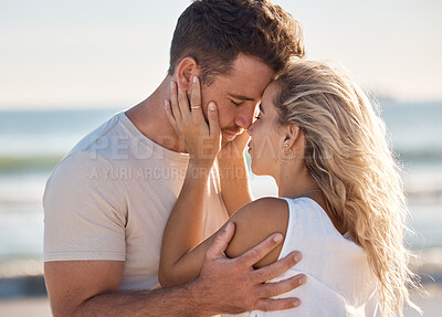 Buy stock photo Love, kiss and beach with a young couple sharing an intimate moment on the coast by the sea or ocean. Nature, romance and travel with a man and woman bonding together on an outdoor date in summer